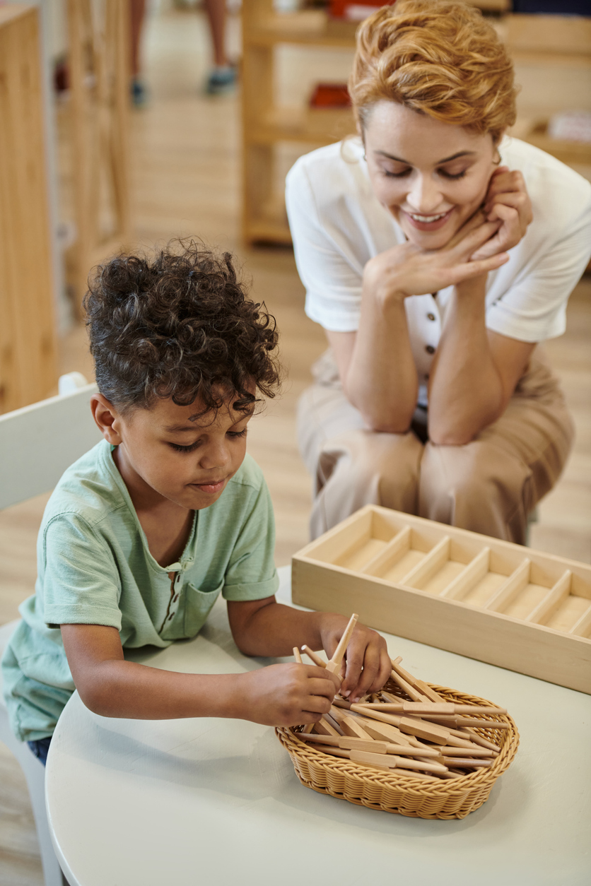 Teacher engages with diverse children during hands-on learning in a Montessori classroom
